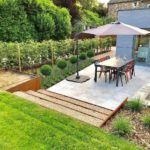 Terrasse avec escalier en gravier et un parasol