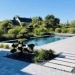 Piscine enterrée à coté de transats blancs au soleil